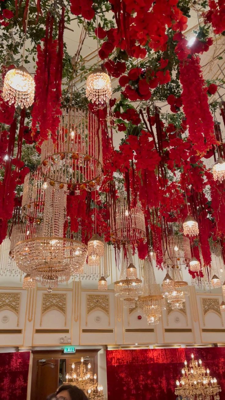 red flowers hanging from the ceiling and chandeliers