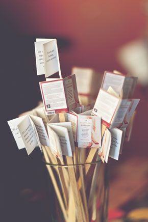 a glass filled with lots of cards sitting on top of a table