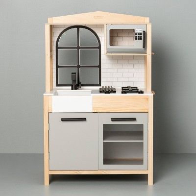 a toy kitchen with an oven, sink and microwave