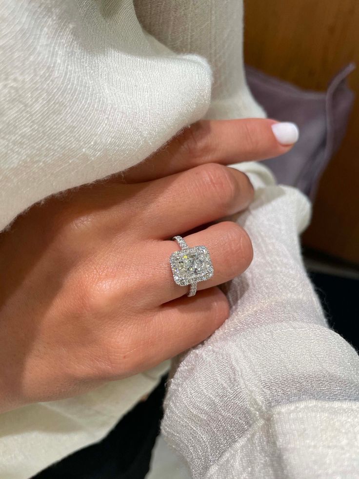 a woman's hand with a diamond ring on it