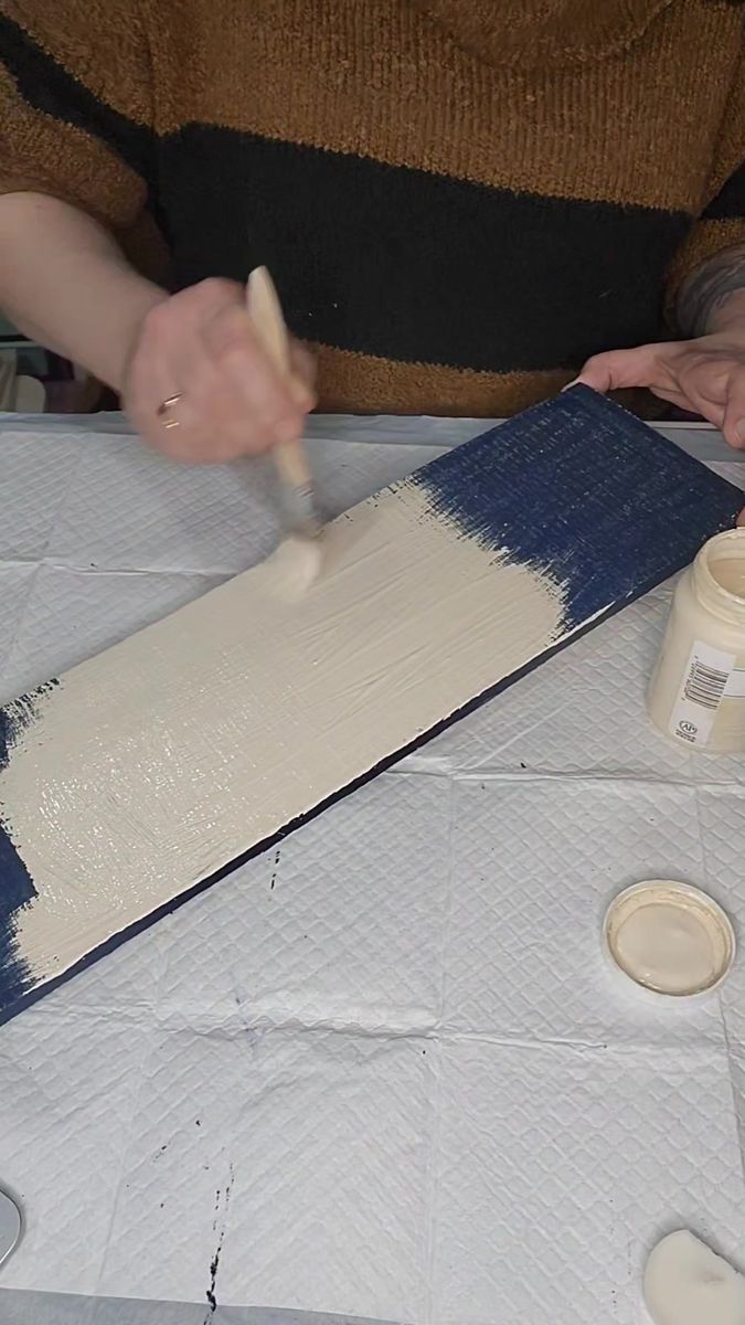 a person is painting on a table with white paint