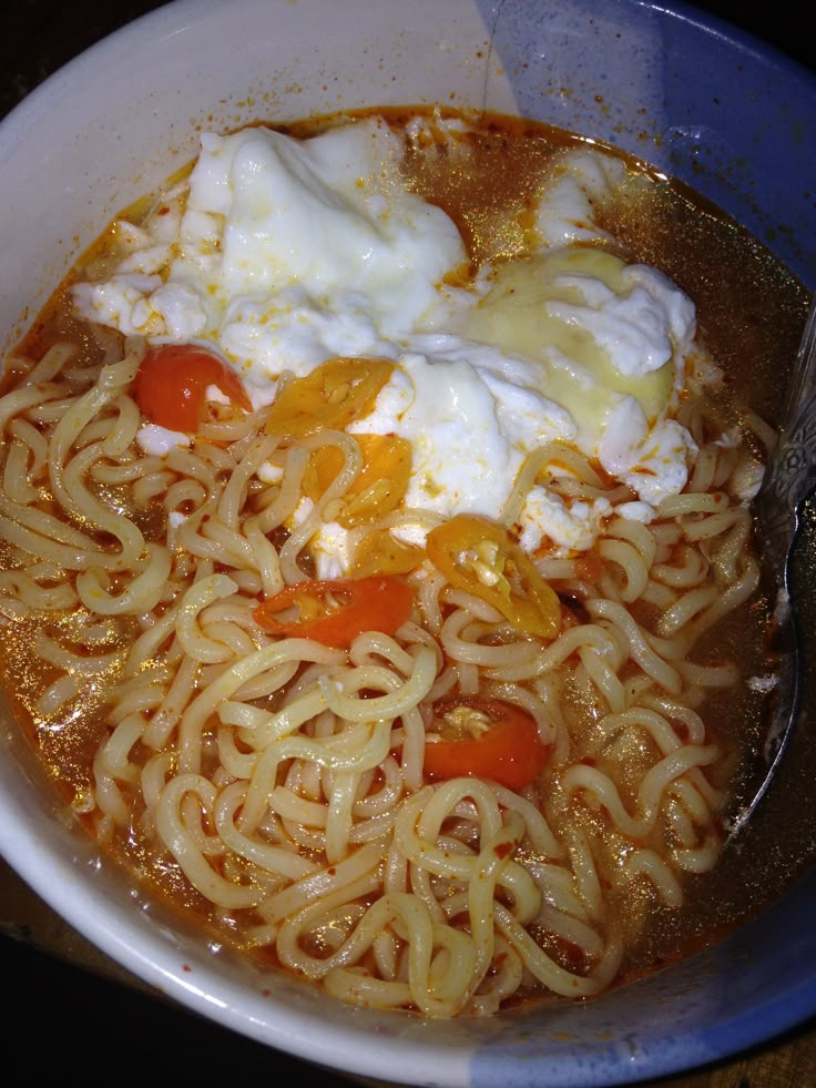 there is noodle soup in the bowl with noodles and eggs on top, ready to be eaten