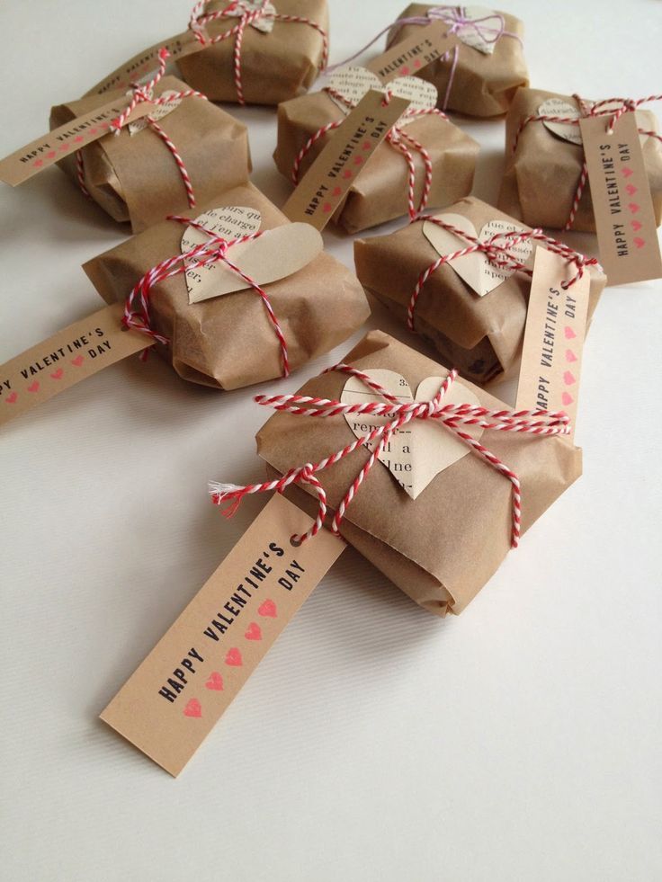 some brown paper bags tied with twine and hearts are sitting on a white table