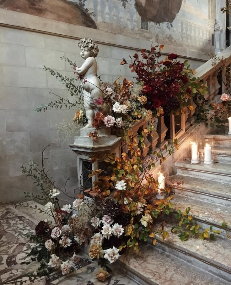 an arrangement of flowers and candles on the stairs