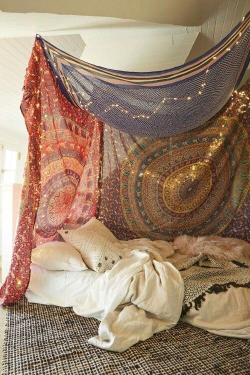 a bed covered in lots of colorful blankets