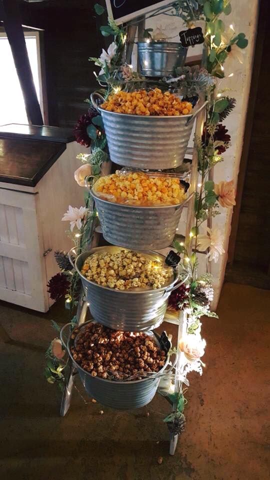 a metal bucket filled with lots of food next to a sign that says, sweet corn