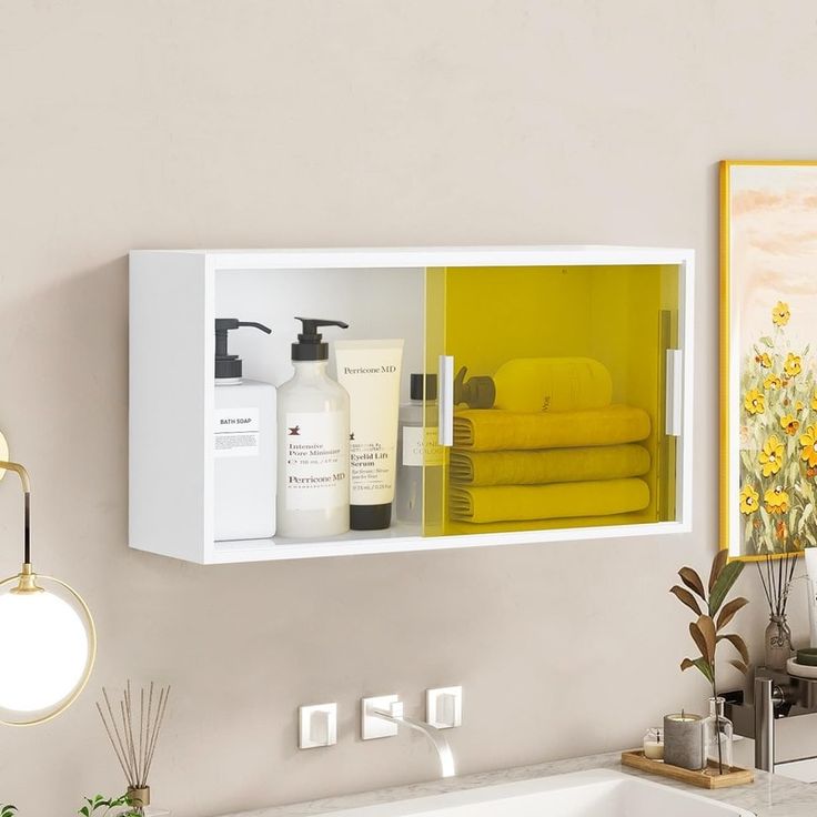 a bathroom with yellow towels and soaps on the shelf next to the bathtub