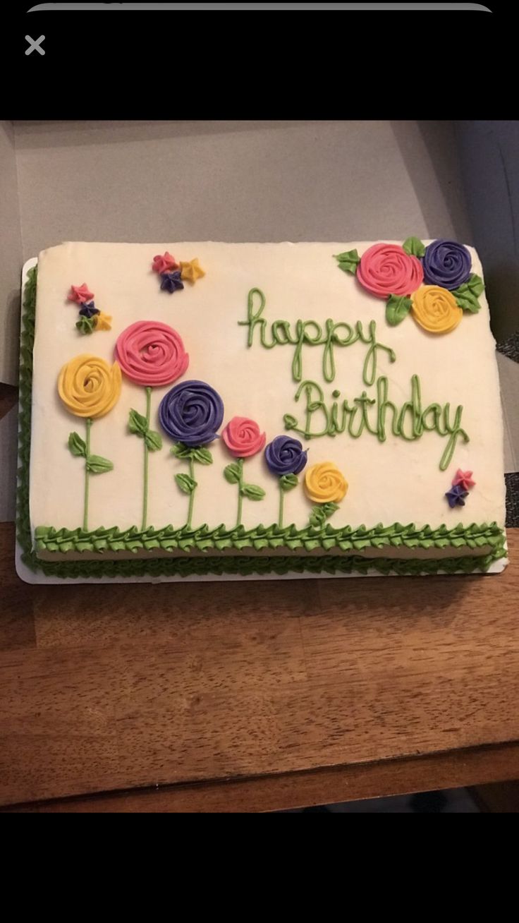 a birthday cake with flowers on it sitting on a table