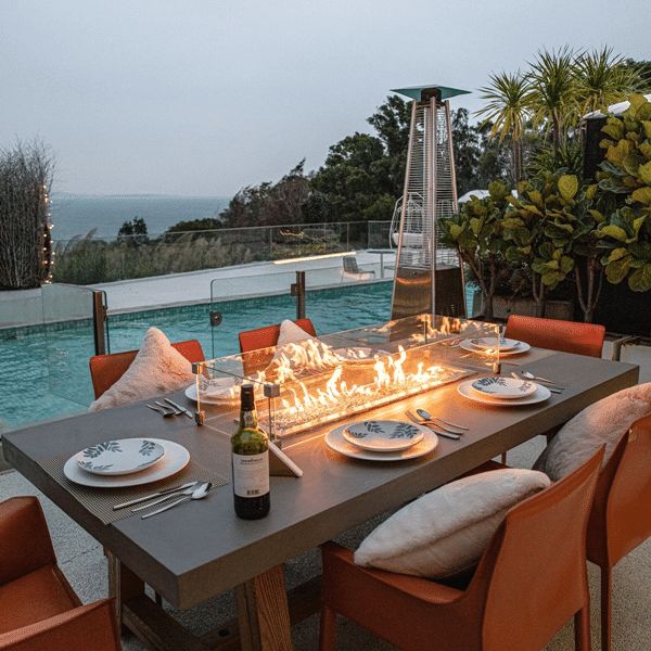 an outdoor dining table with candles on it