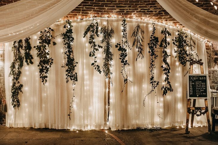 the backdrop is decorated with greenery and lights