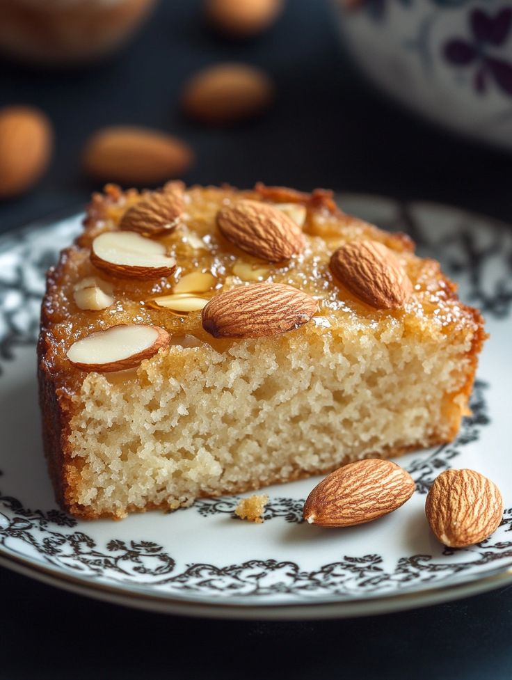 a piece of cake on a plate with almonds