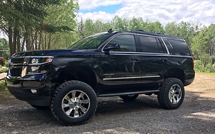 a black truck is parked in the dirt