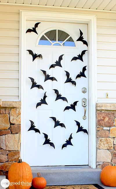 a front door decorated with bats and pumpkins