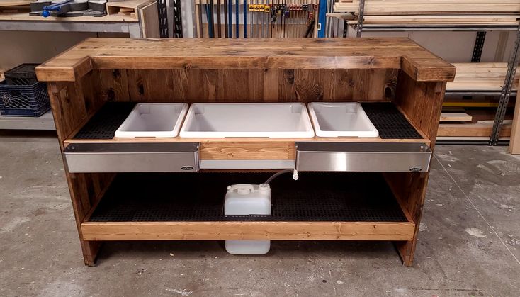 a kitchen island made out of wood and steel with two white dishes on the top