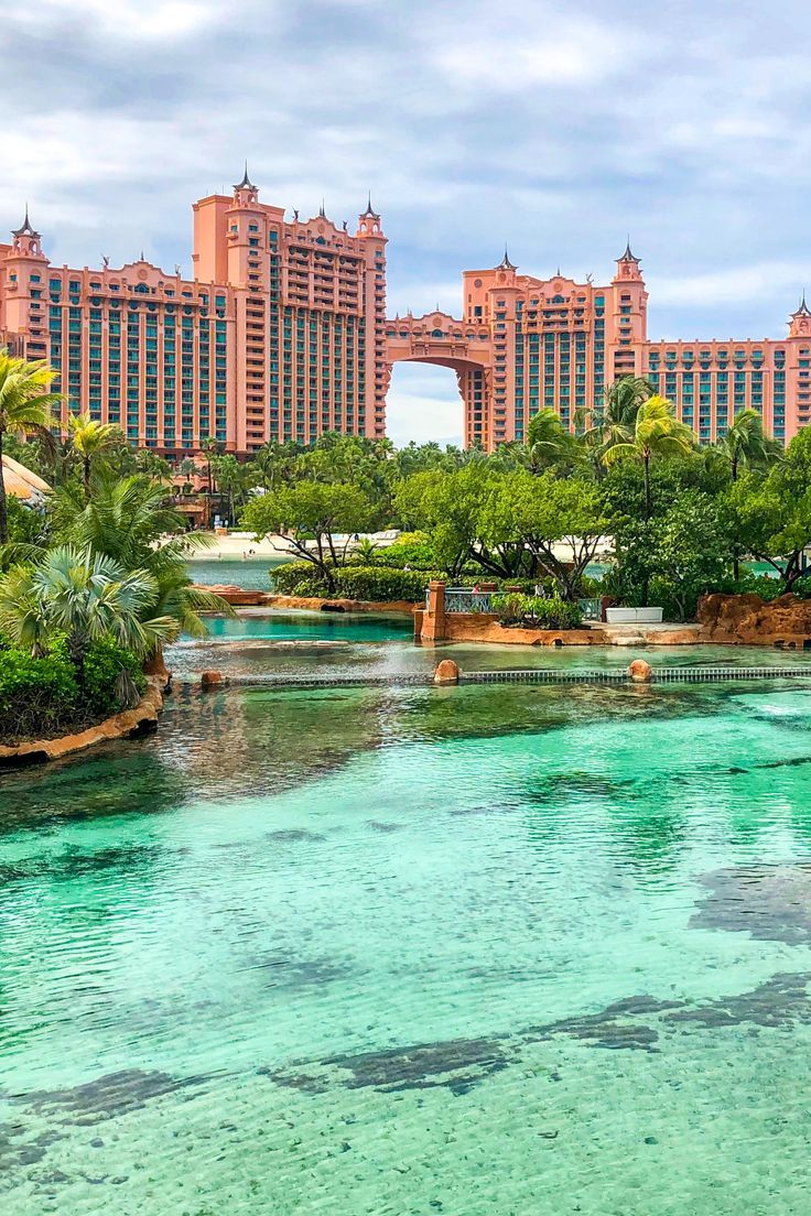 the water is crystal clear and blue in front of some very high rise hotel buildings