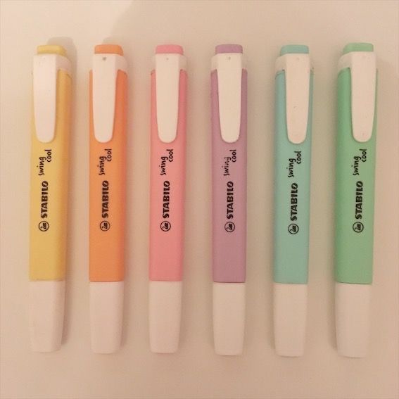 four pens are lined up in different colors and sizes with writing on the top one