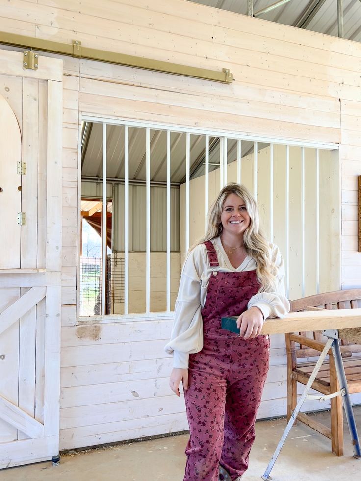 a woman standing next to a wooden table