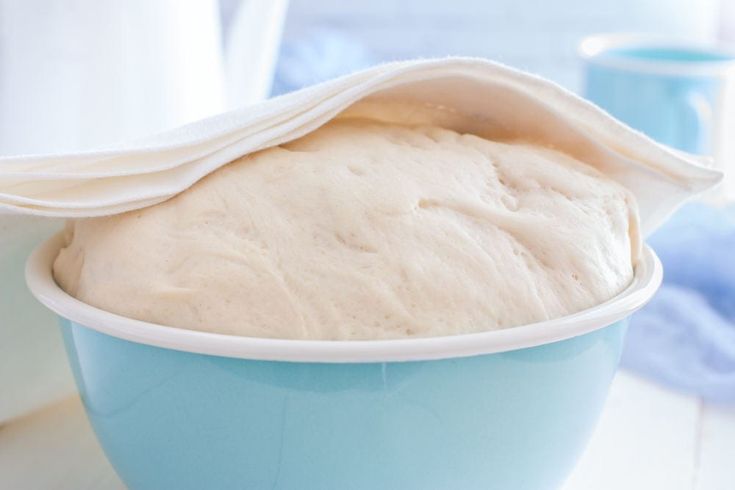 a blue bowl filled with white bread on top of a table