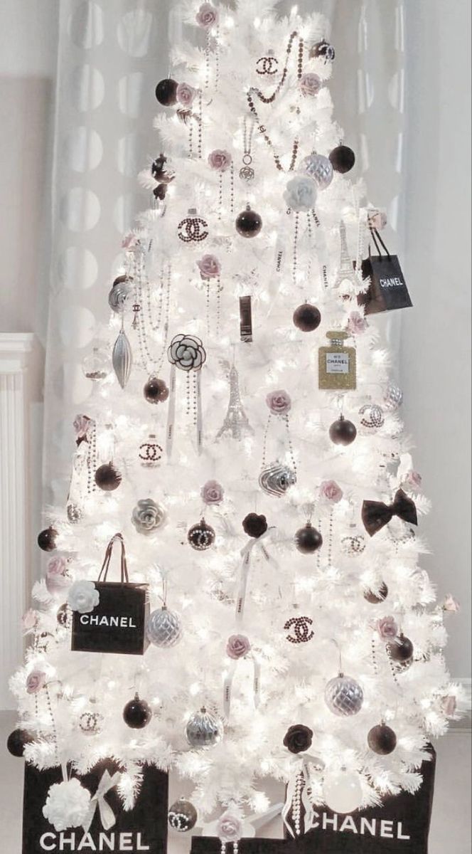 a white christmas tree decorated with chandeliers and black and white tags on it