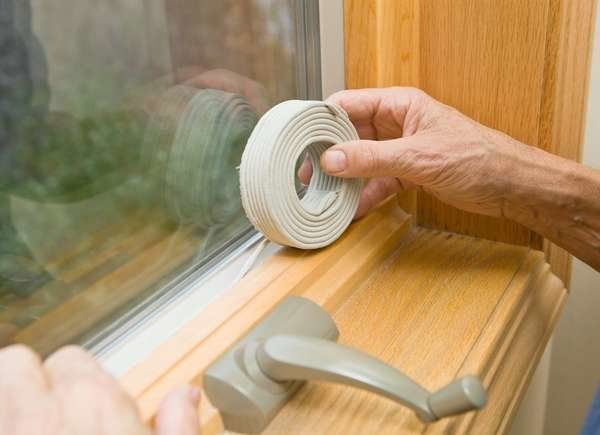 a person is opening the window with a white tape