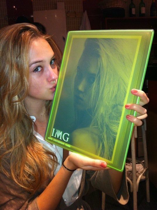 a young woman holding up a photo in front of her face with the word img on it