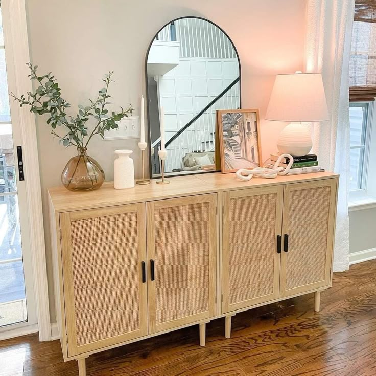 a dresser with a mirror and vase on it