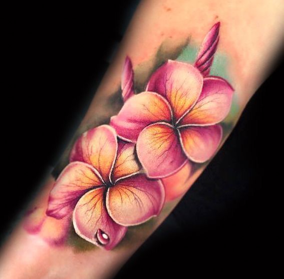 a tattoo with pink flowers on the arm