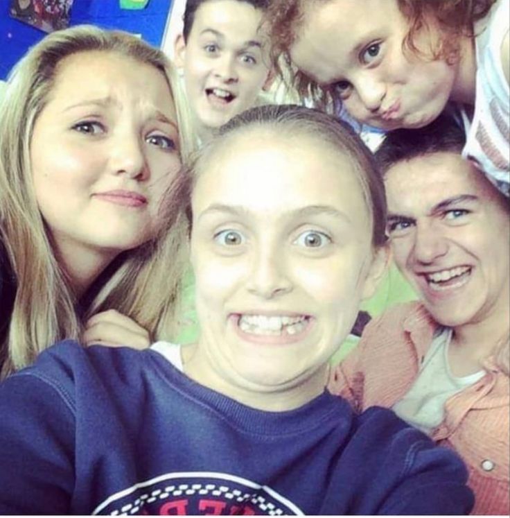 a group of young people posing for a photo with one woman smiling at the camera