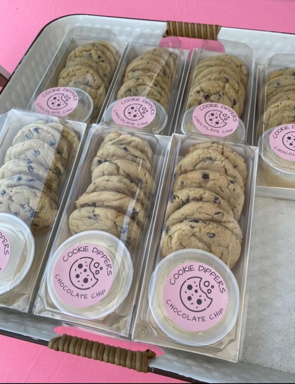 there are many cookies and ice creams in the box on the table, with pink labels