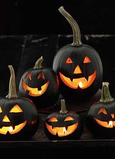 five carved pumpkins sitting on top of a table