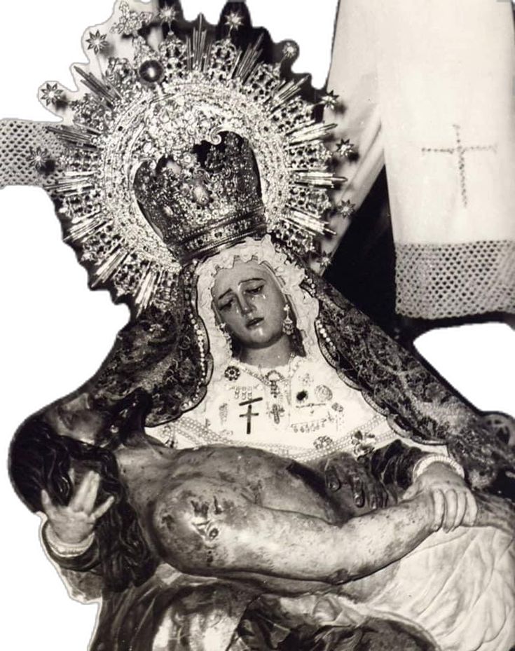 an old statue of the virgin mary holding a baby jesus in her arms with a cross on it