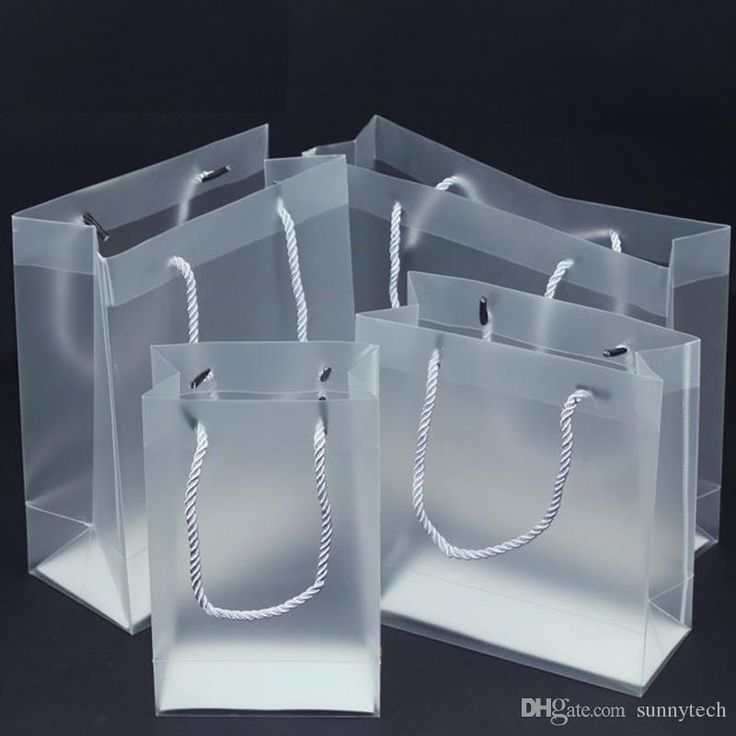 three bags with rope handles are shown on a black surface, one is white and the other is clear