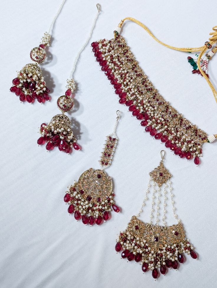 A semi-Indian bridal set is a stunning and elegant jewelry ensemble that beautifully combines elements of traditional Indian craftsmanship with modern design sensibilities. This exquisite set is designed for brides who wish to strike a perfect balance between traditional and contemporary aesthetics on their special day. The semi-Indian bridal set typically includes a harmonious combination of statement necklaces, earrings, tikka, and jummar all carefully crafted with intricate detailing and luxu Indian Brides Jewelry, Indian Jewelry Sets, Red Jewelry, Indian Wedding Outfits, Bride Jewellery, Bride Style, Elegant Jewelry, Indian Bridal, Bridal Sets