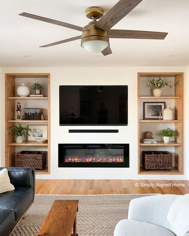 a living room with a couch, fireplace and television on the wall in front of it