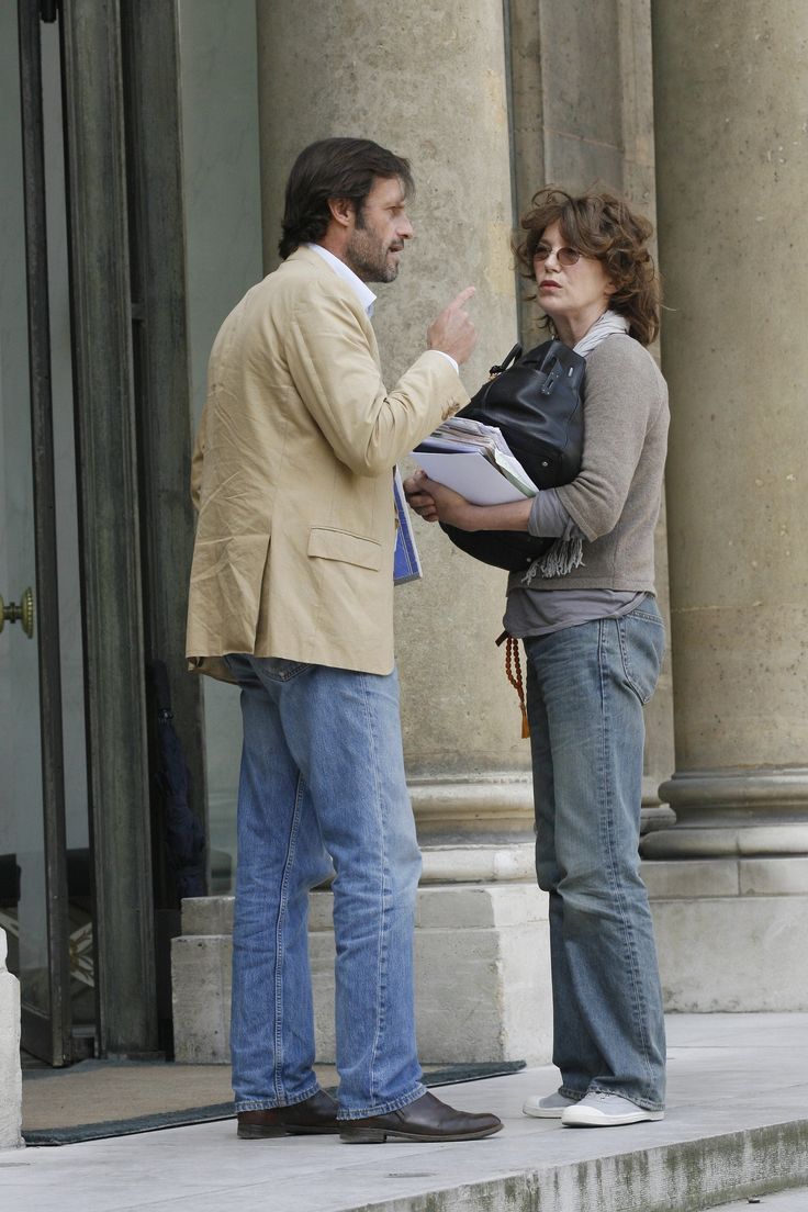 a man and woman standing on steps talking to each other