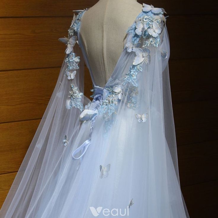 a white dress with blue flowers and butterflies on the back is displayed in front of a mannequin