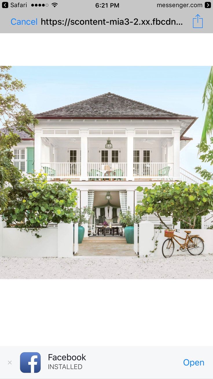 an image of a white house with green shutters on the front and second story