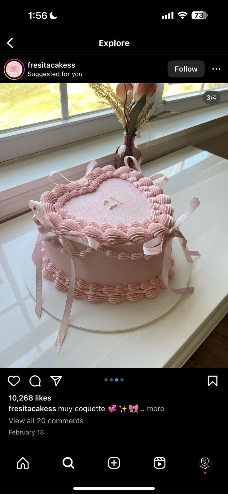 a pink cake sitting on top of a white counter next to a window sill