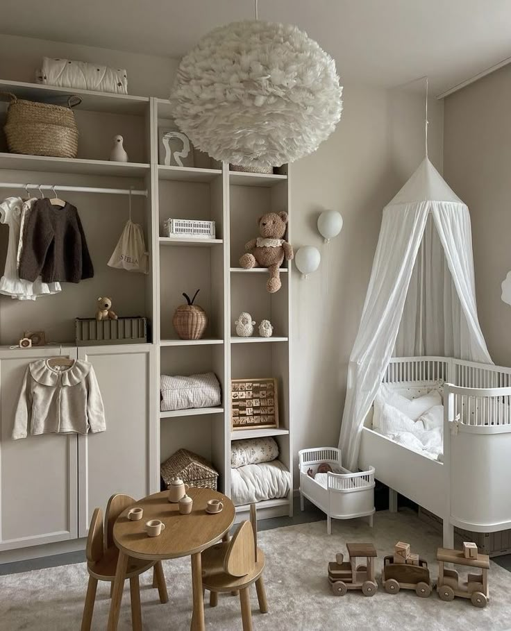 a baby's room with lots of white furniture and accessories on shelves, including a crib