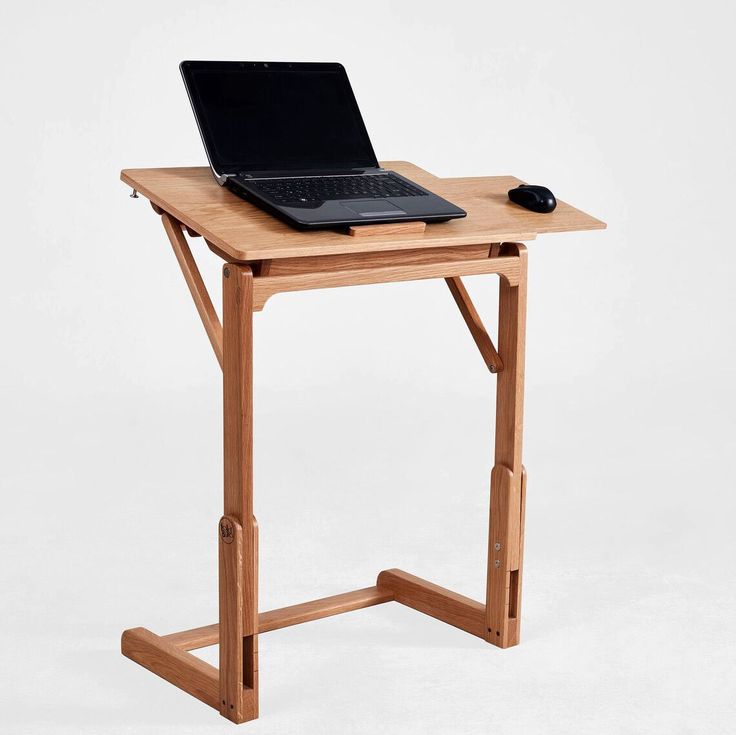 a laptop computer sitting on top of a wooden table next to a mouse and keyboard