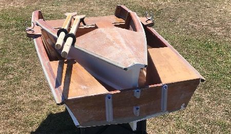 a small wooden boat with two oars on the front and one in the back