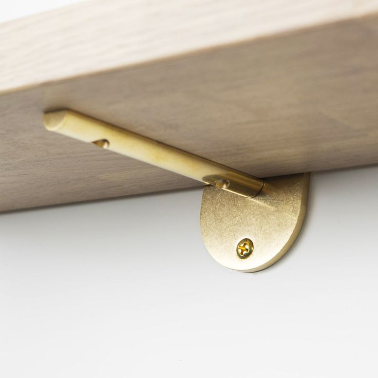 a close up of a wooden shelf with a metal hook