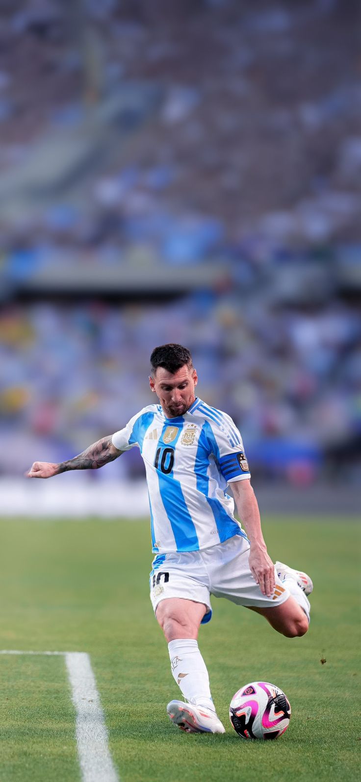 a man kicking a soccer ball on top of a field