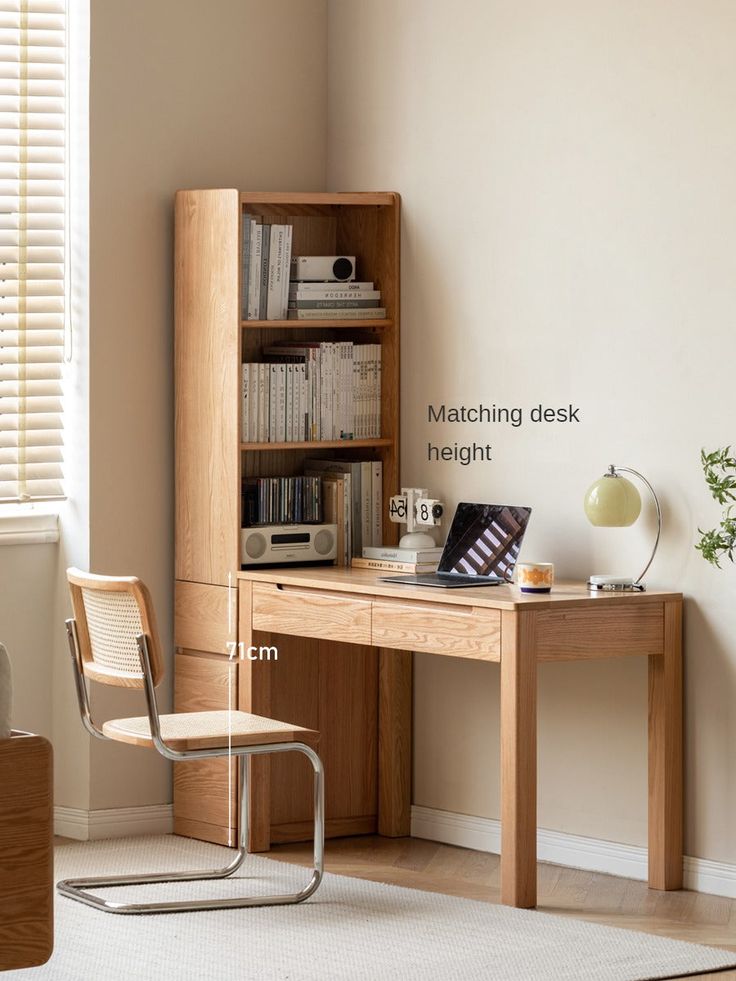 a wooden desk with a laptop computer on top of it next to a book shelf