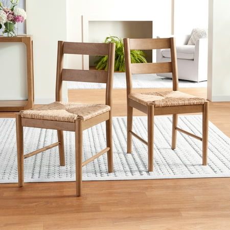 two wooden chairs sitting on top of a white rug