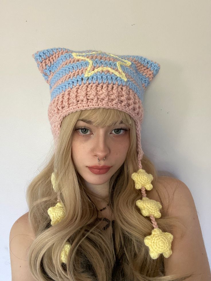 a woman with long blonde hair wearing a crocheted hat