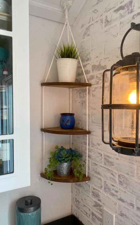 a light hanging from the side of a brick wall next to a potted plant