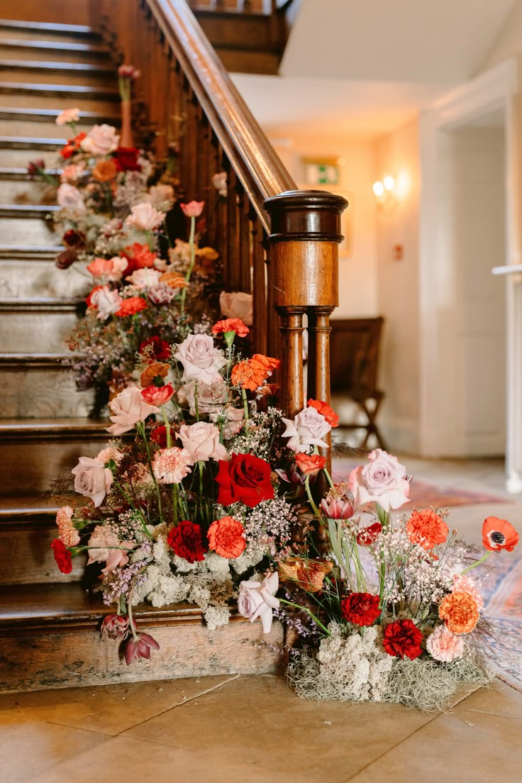 a bunch of flowers that are sitting on the ground next to some kind of stairs