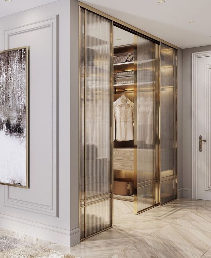 a walk in closet with mirrored doors and white walls