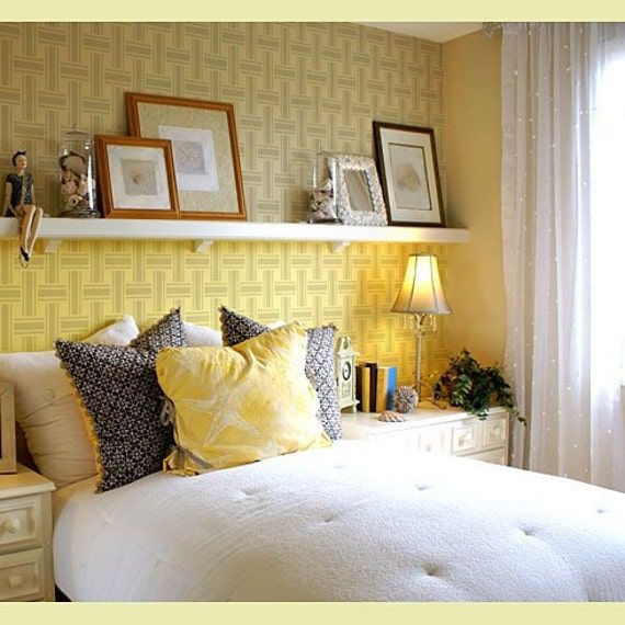 a bedroom with yellow walls and white bedding, two framed pictures on the wall